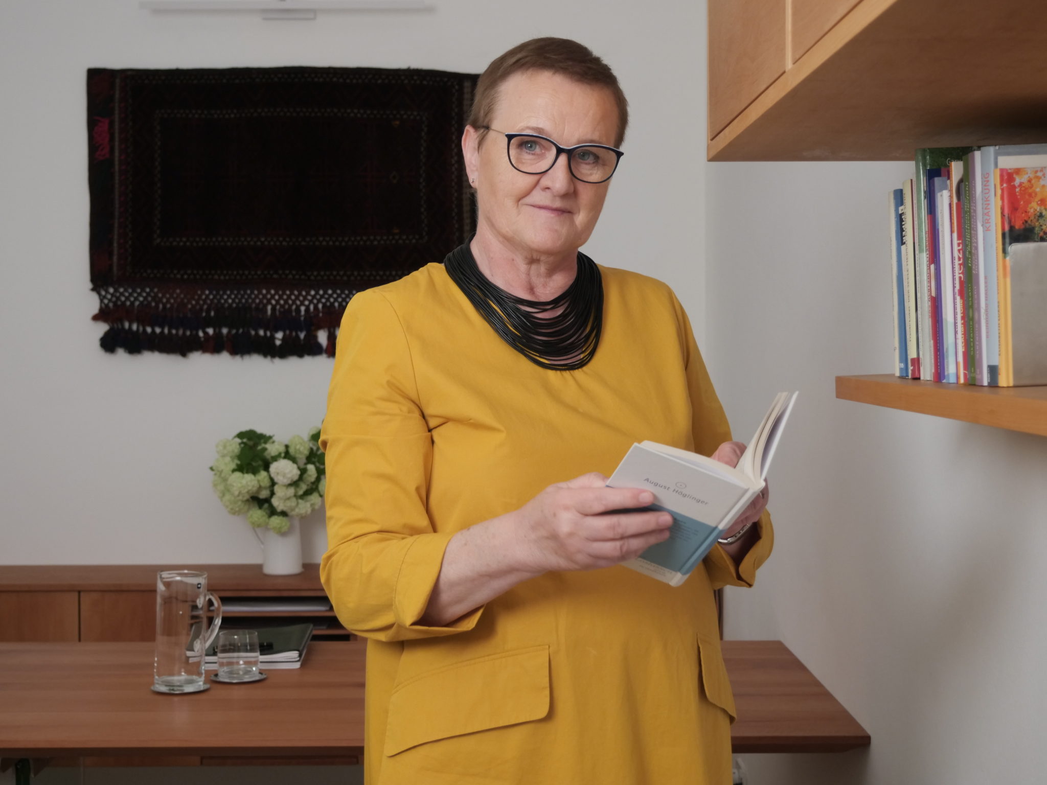 Psychotherapeutin-Elfriede-Ulbl-Buch Psychotherapeutin Elfriede Ulbl stehend mit einem Buch in den Händen